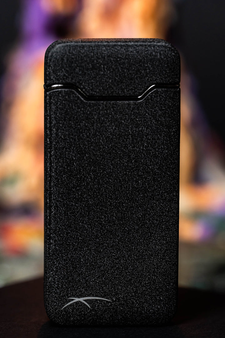 Black Flare lighter with blurry multicolored candle in background