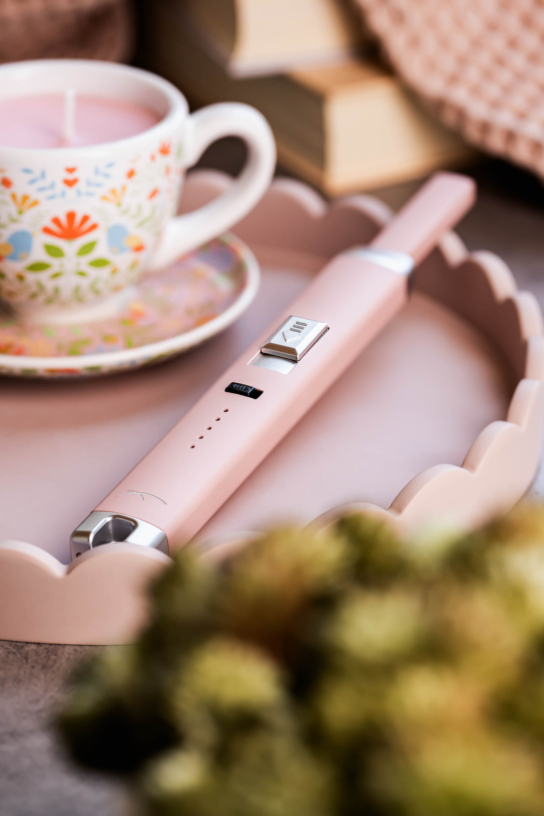 Sizzle Pitmaster USB rechargeable lighter in pink color on a serving tray beside a teacup