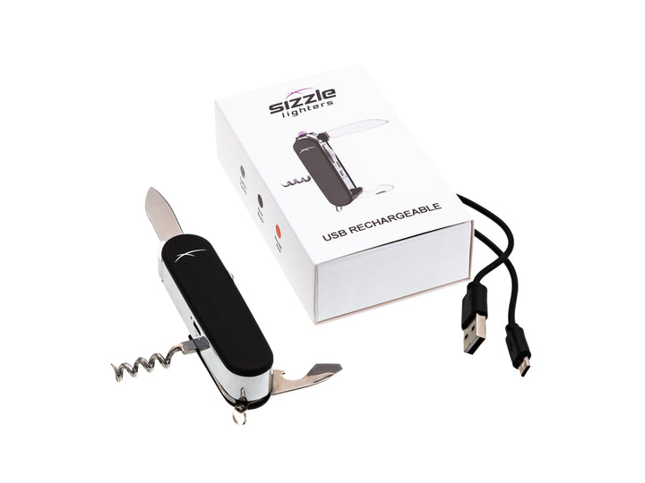 Sizzle Scout USB rechargeable lighter/survival device in black color with blade, corkscrew and opener extended sitting beside product box with USB charge cord